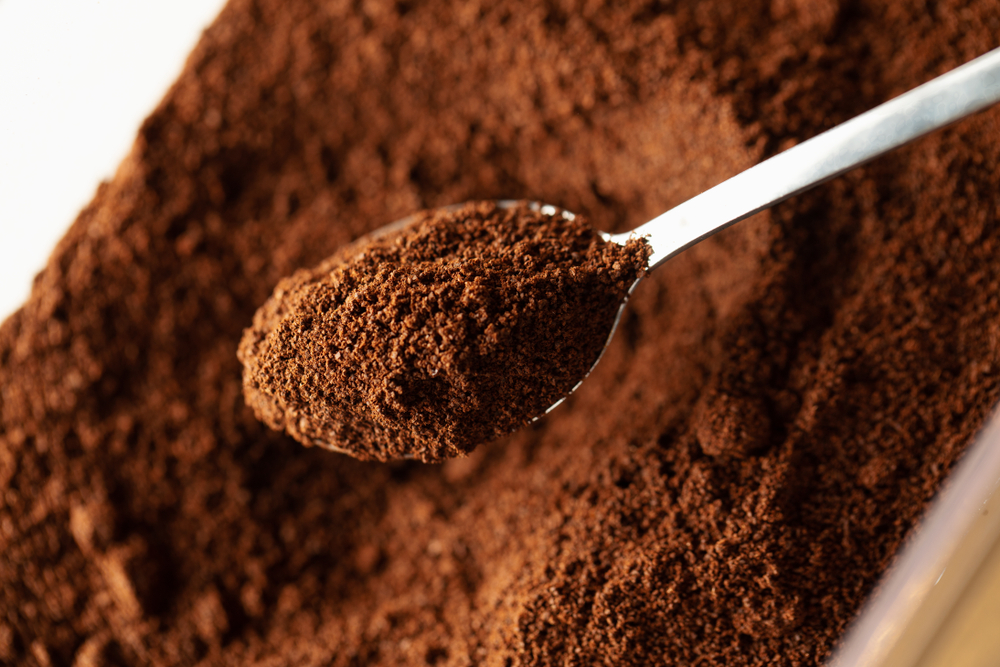 Ground coffee in spoon, natural coffee background, macro
